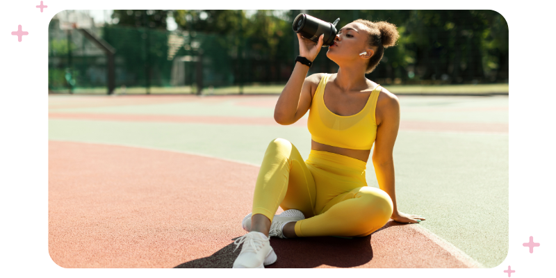 Young woman taking a break from outdoor exercise to drink water