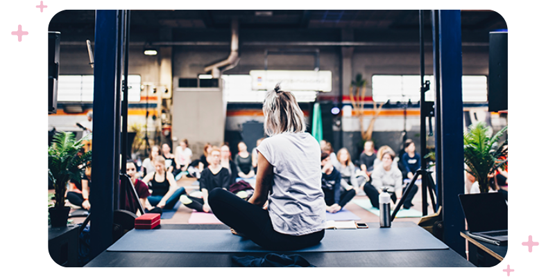 Busy gym instructor teaching a full class