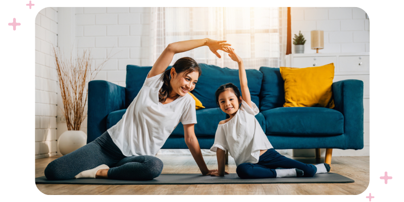 A mother and young daughter exercising on the living room floor