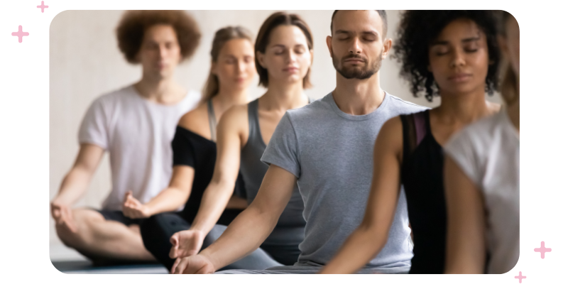 Group of men and women meditating at a wellness retreat