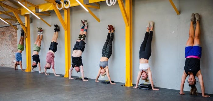 Members of CrossFit Tay Ho doing handstands