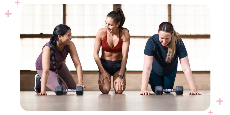 Instructor guiding two women through a workout