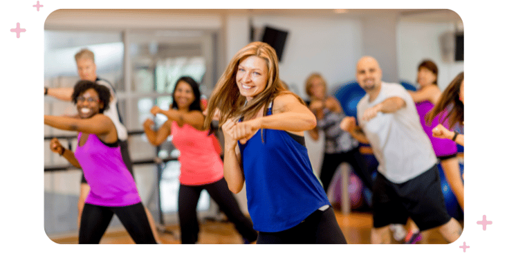 Group of gym-goers actively participating in a fun class