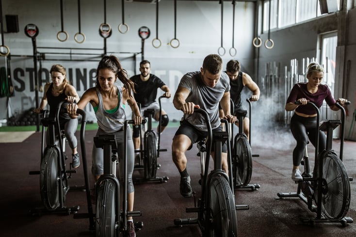 Crossfitters at a CrossFit box taking part in a WOD on CrossFit equipment.