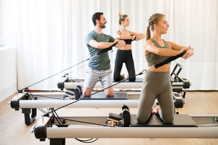 Clients of a Pilates business using Pilates machines in a Pilates studio