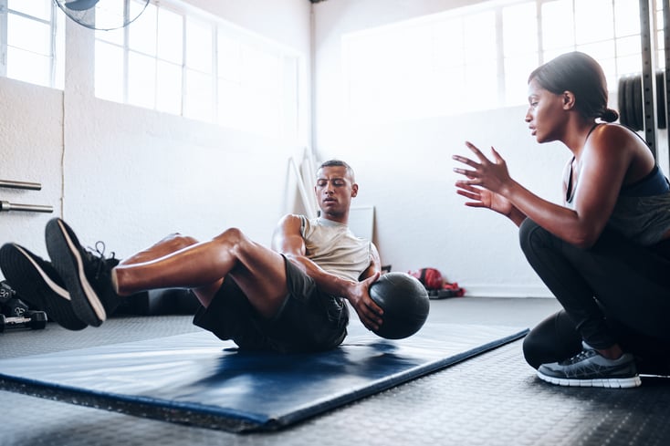 A personal trainer leading a personal training client through an exercise program.