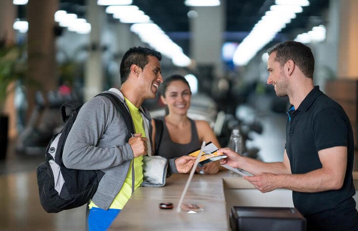 A fitness business owner welcoming a new client to their gym or studio