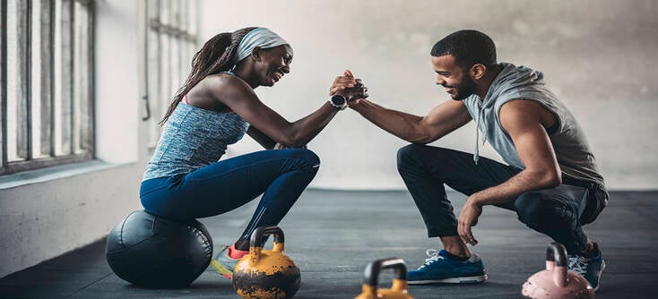 A personal trainer sharing a high five with their personal training client