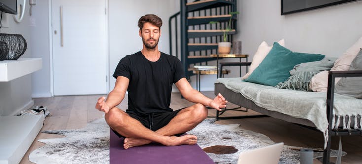 man meditating during an online fitness class