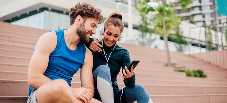 Two fitness fanatics listening to a fitness podcast together.