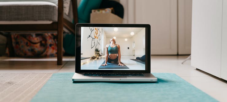 woman doing a pilates class on her computer at home
