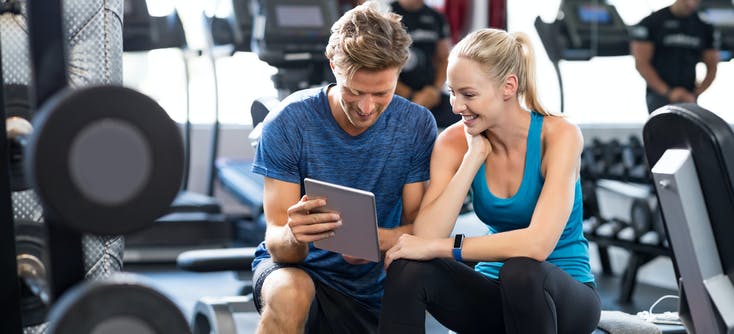 two people at the gym looking at a tablet