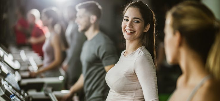 pregnant fitness customer on a treadmill in a group class