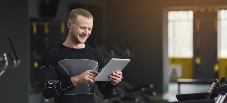 gym owner checking his reports on his tablet