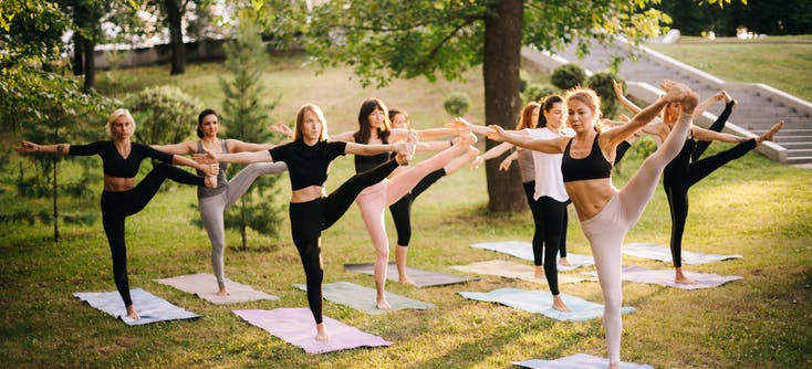 group of women doing pilates in the park
