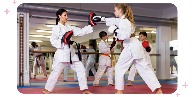 A martial arts teacher trains with a young martial arts student in their martial arts school