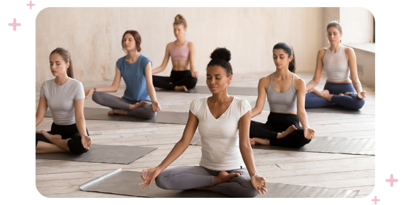 Yogis sitting on yoga mats during one of their yoga classes.