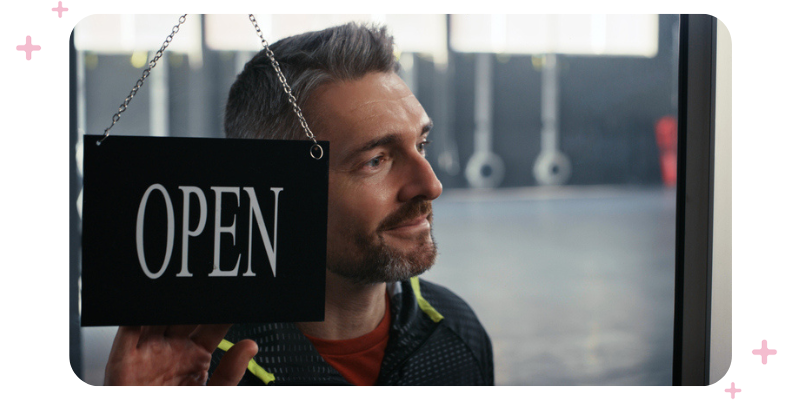 Gym owner turning the sign on the door to "open".