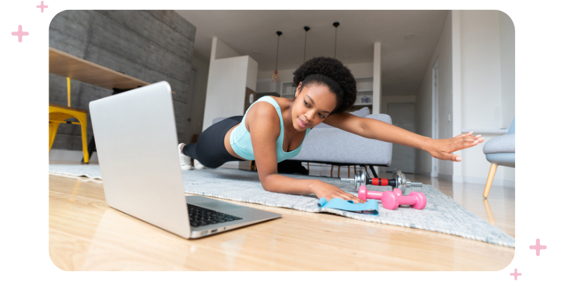 A girl working out in her living room in front of her laptop.