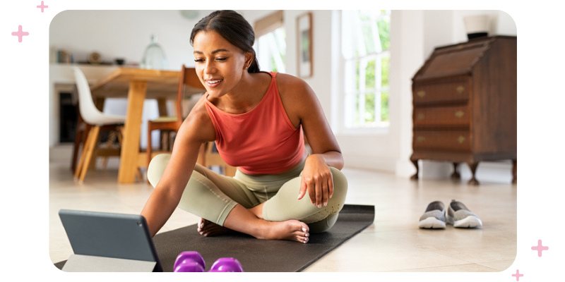 A woman getting ready to start a workout at home in front of the computer.