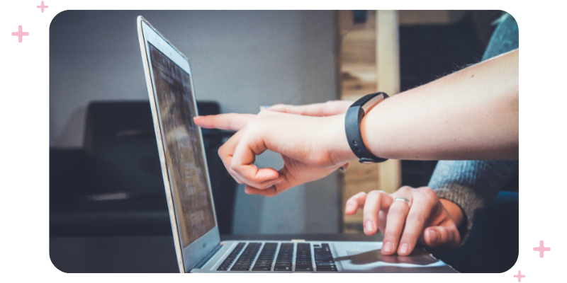 Two people working in front of a laptop.