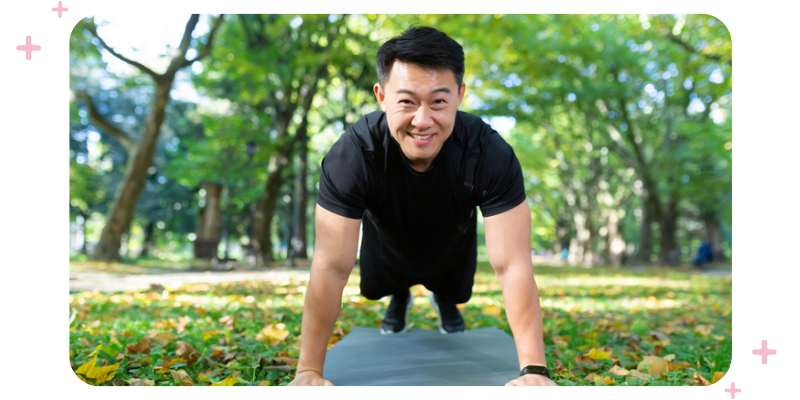 A man doing push-ups in the park.