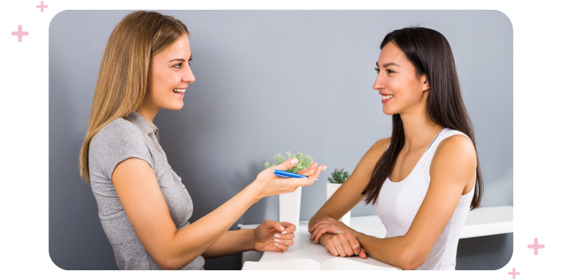 A woman talking to the receptionist at a gym.