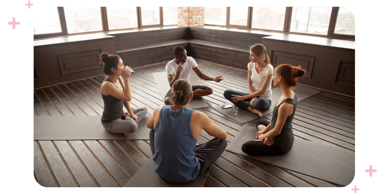 A group of staff members having a meeting on the floor of their studio.