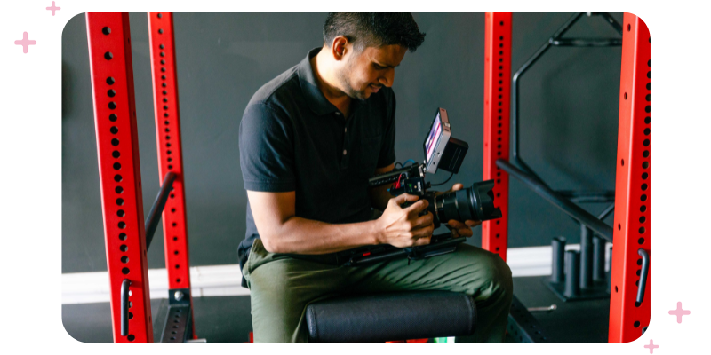 A man filming a promotional video at a gym.