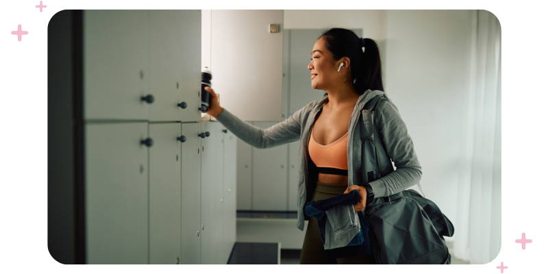 A woman opening a locker at the gym.